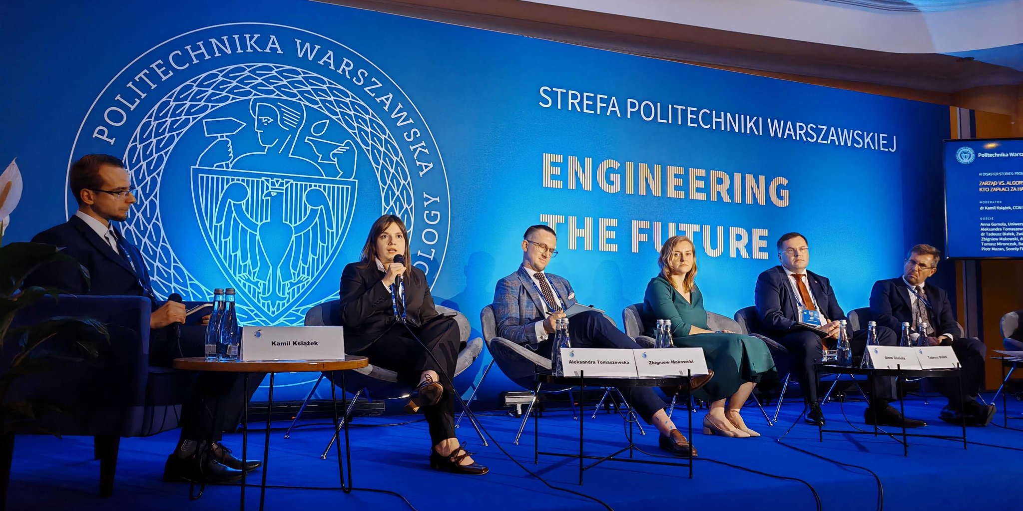 Kamil Książek moderating the panel on AI in finance